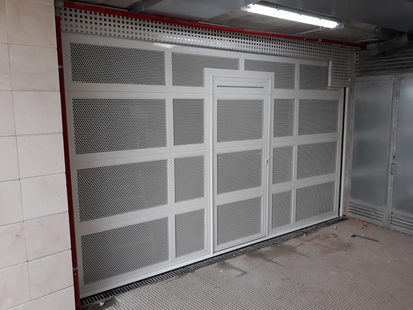 puerta seccional aluminio microperforada y peatonal integrada